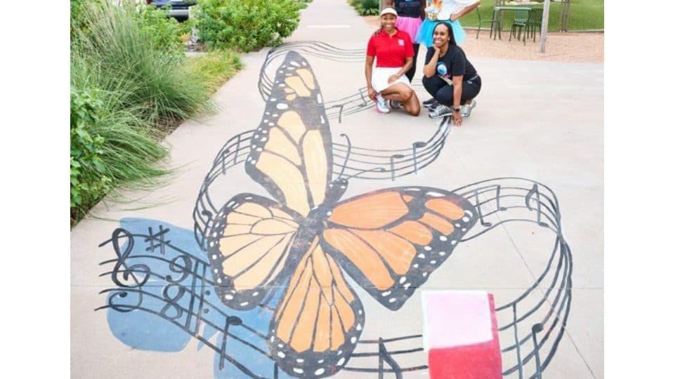 Chalk drawing of a monarch butterfly and music notes on the sidewalk